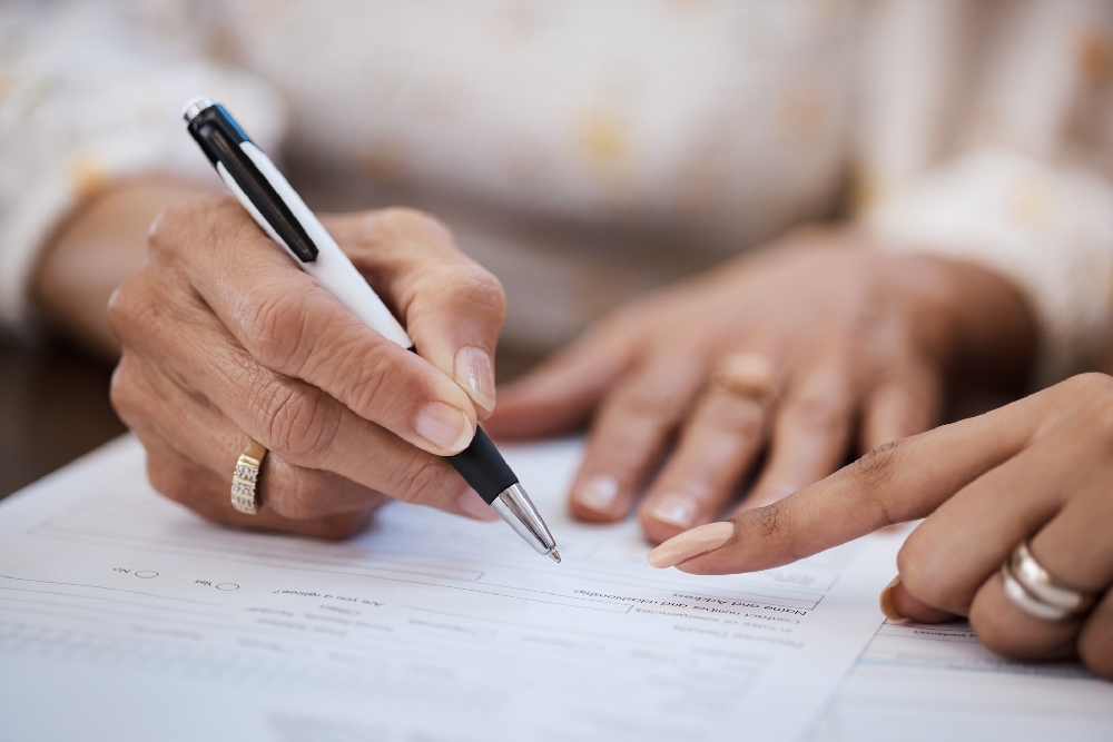 two people writing a document
